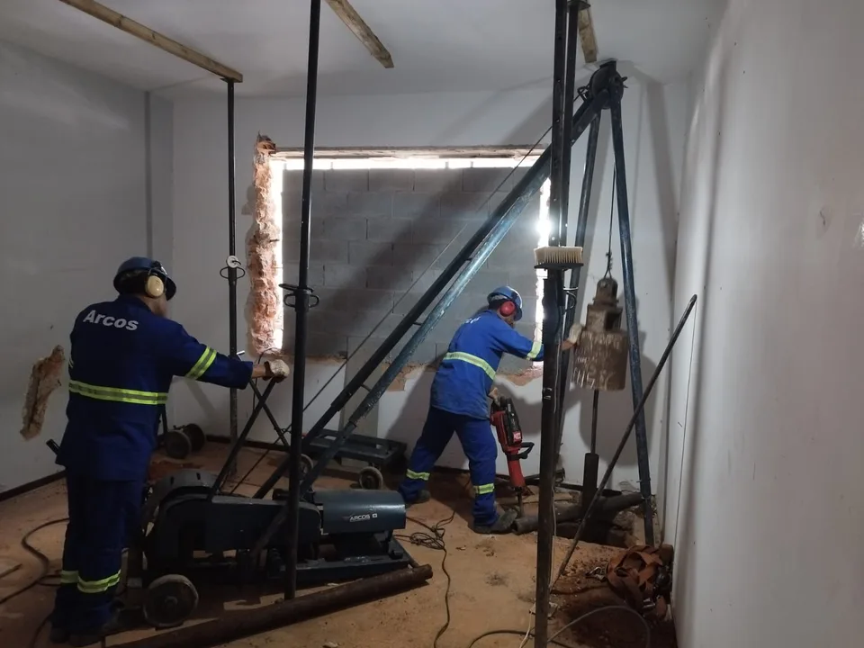 Profissionais da ARCOS operando equipamento de microestaca em ambiente interno