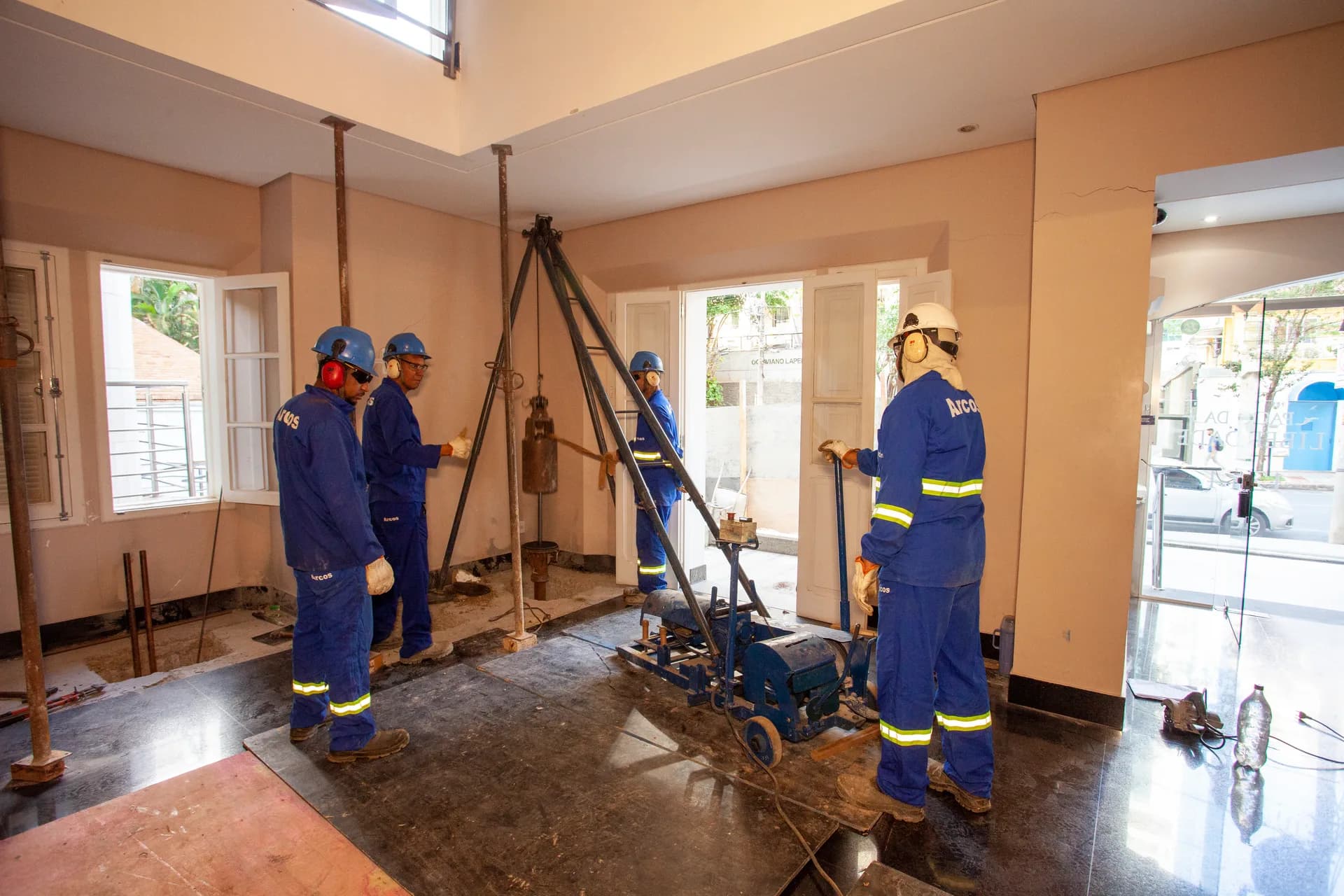 Equipe da ARCOS executando a Microestaca Arcos com tripé e equipamento compacto dentro de um imóvel